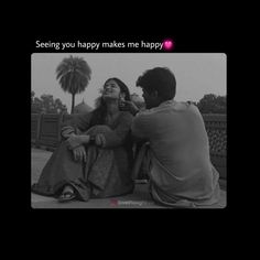 a man and woman sitting next to each other in front of a palm tree with the caption seeing you happy makes me happy