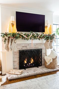 a fireplace decorated for christmas with stockings and lights