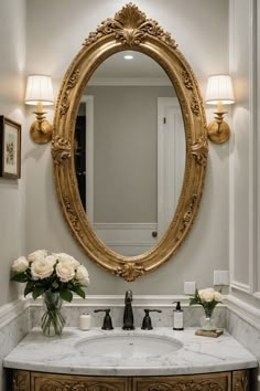 a bathroom sink with a large mirror above it and flowers in the vase on the counter