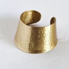 Handmade satin brass hammered sleeve gold cuff bangle bracelet. Arrives in logo drawstring protective pouch Artisan Gold Cuff Bracelet For Gift, Brass Cuff Bracelet As Gift, Artisan Gold Bangle Cuff Bracelet, Unique Hammered Gold Bracelets, Artisan Hammered Gold Bracelets, Artisan Gold Hammered Bracelets, Artisan Gold Cuff Bangle Bracelet, Handmade Gold Cuff Bracelet For Festival, Unique Gold Hammered Bracelets