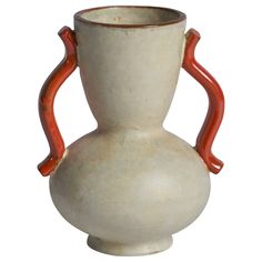 a white vase with red handles is shown against a white background and has an orange handle