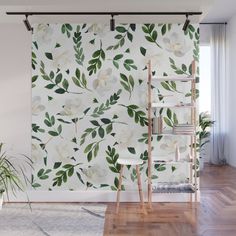 the wallpaper in this room is painted with white flowers and green leafy leaves