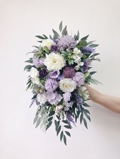 a bouquet of flowers is being held by someone's hand