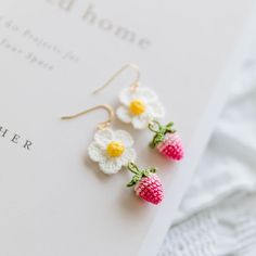 three tiny crocheted flowers are attached to earrings