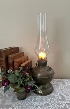 a table with a lamp, potted plant and some books on top of it