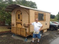 a man standing in front of a tiny house