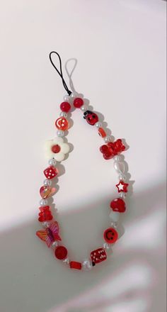 a red and white beaded necklace hanging from a string