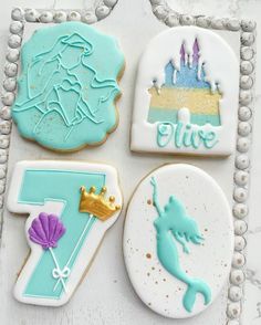 four decorated cookies sitting on top of a table