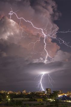 lightning strikes over the city at night time