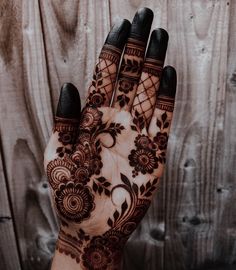 a woman's hand is decorated with hennap and flower designs on it