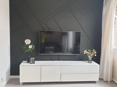 a flat screen tv sitting on top of a white entertainment center