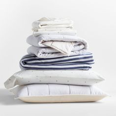 stack of pillows and blankets on white background