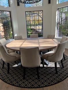 a dining room table surrounded by chairs and windows