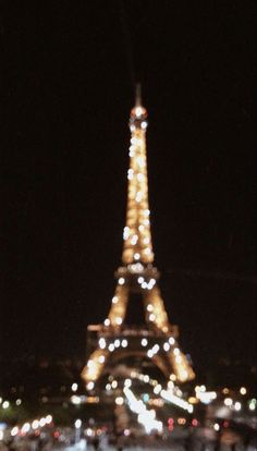 the eiffel tower is lit up at night with lights on it's sides