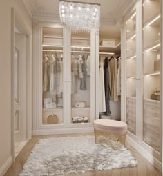 a walk in closet with chandelier and dressing room furniture on the floor next to it