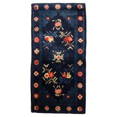 a blue rug with red, yellow and green flowers on the bottom is shown in front of a white background