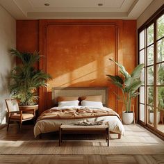 a bedroom with an orange wall and wooden flooring that has a large bed in it