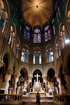 the inside of a church with stained glass windows and statues on either side of the alter