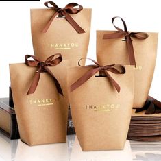 four brown paper bags tied with ribbon and thank you written on the side, sitting next to each other