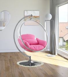 a living room with a swing chair in the middle and a window to the side