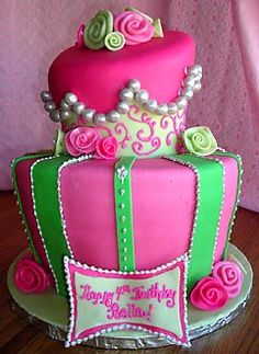 the cake is decorated with pink and green icing