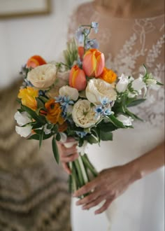 a woman holding a bouquet of flowers in her hands