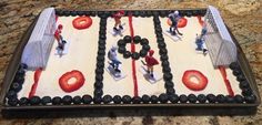 a cake that looks like a soccer field with people on it and the goal is made out of frosting