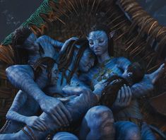 some people with blue paint on their faces and body are sitting in a wicker chair