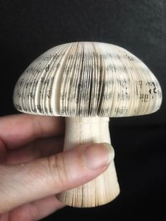 a hand is holding a small mushroom with sheet music on it's back end