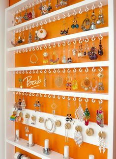 an orange and white wall with earrings on it's shelves in front of the door