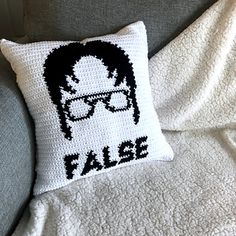 a crocheted pillow with the words false on it and a photo of a man wearing glasses