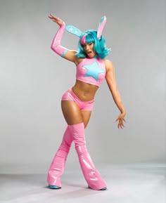 a woman dressed in pink and blue is posing for the camera with her arms outstretched