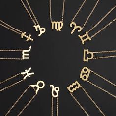 zodiac signs are arranged in a circle on a black background with gold chain necklaces