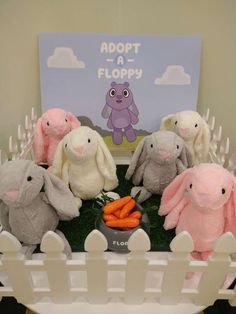 there are many stuffed animals on display in the room with carrots and a sign that says adopt a floppyy