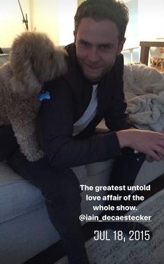 a man sitting on top of a couch holding a dog