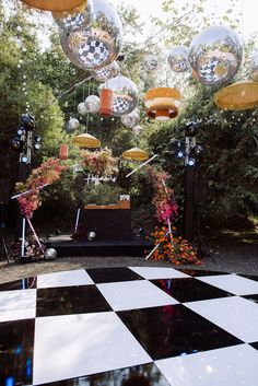 a black and white checkered floor with disco balls hanging from it