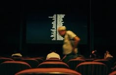 people sitting in an auditorium watching a movie