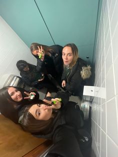 four young women taking selfies in the bathroom