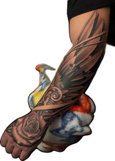 a person with a tattoo on their arm holding a bird and flower in his hand