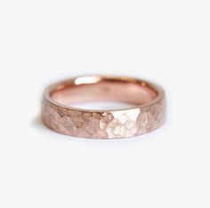 a rose gold wedding band with rough textured finish on the outside and inside side