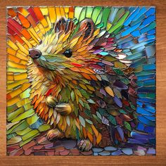 an animal made out of stained glass sitting on top of a wooden table next to a wall