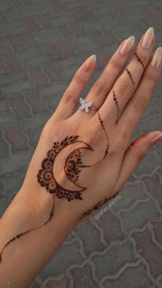 a woman's hand with henna tattoos on it