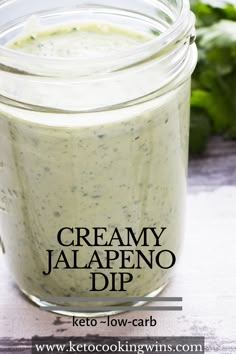 a jar filled with creamy jalapeno dip on top of a table