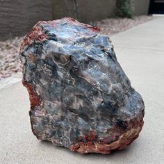 a large rock sitting on top of a sidewalk