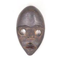 an old mask with two eyes and a mustache on the nose, against a white background