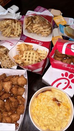 many different types of food are sitting on the table, including waffle fries and macaroni and cheese