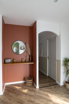 a room with a mirror, shelf and potted plant