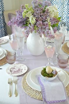 the table is set with purple and white flowers