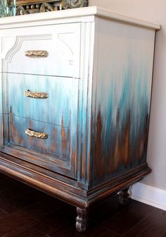 an old dresser painted with blue and gold paint