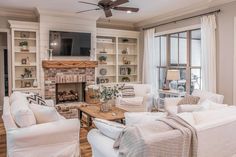 a living room filled with furniture and a flat screen tv mounted on the wall above a fire place